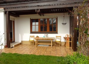 Terasse Balkon überdacht . Gartenstühle Holztisch .