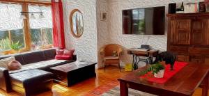 FeWo Mering Wohnzimmer Ledercouch Wandmonitor Highboard Tisch Kolonialstil